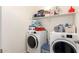 Functional laundry room featuring a washer, dryer, and ample storage shelves at 14870 W Encanto Blvd # 2138, Goodyear, AZ 85395
