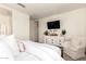Bright main bedroom with a queen bed, an ensuite bathroom, a decorative console and lots of natural light at 14870 W Encanto Blvd # 2138, Goodyear, AZ 85395