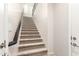 Carpeted staircase with a dark wood railing leading to the upper levels of the home at 14870 W Encanto Blvd # 2138, Goodyear, AZ 85395