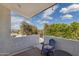 A balcony featuring a view of lush greenery, a chair, and a small table at 15027 N 19Th Way, Phoenix, AZ 85022