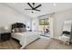 Stylish bedroom featuring a plush bed, a ceiling fan, and access to a private balcony at 15027 N 19Th Way, Phoenix, AZ 85022