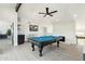 Spacious game room featuring a well-lit billiards table, fireplace, and a modern ceiling fan at 15027 N 19Th Way, Phoenix, AZ 85022