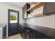 Laundry room with black cabinetry, an accent wall, and plenty of storage space at 15027 N 19Th Way, Phoenix, AZ 85022