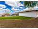 Spacious backyard with green grass and white exterior of home in a secure fenced pool area at 1756 N Summer Cir, Mesa, AZ 85203