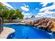 Backyard swimming pool features a rock waterfall, built-in table, and slide for backyard fun at 1756 N Summer Cir, Mesa, AZ 85203