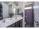 This bathroom features a double vanity, a large mirror, dark brown cabinets, and a combination shower and tub at 18731 W San Juan Ave, Litchfield Park, AZ 85340
