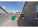 Exterior of the home showing side yard with gravel and trash bins, and the side of the house at 18731 W San Juan Ave, Litchfield Park, AZ 85340