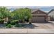 Charming exterior featuring a two-car garage, well-manicured trees and landscaped yard at 18731 W San Juan Ave, Litchfield Park, AZ 85340