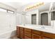 Bathroom featuring a double sink vanity, shower-tub combination, and a large mirror at 1944 N Lazona Dr, Mesa, AZ 85203