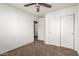 Bedroom with plush carpet flooring, a ceiling fan, and a sliding door closet for storage at 1944 N Lazona Dr, Mesa, AZ 85203