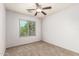 Bedroom with plush carpet flooring, ceiling fan, and a window for natural light at 1944 N Lazona Dr, Mesa, AZ 85203