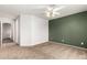 Bedroom featuring neutral carpet, green accent wall, ceiling fan, and open doorway at 1944 N Lazona Dr, Mesa, AZ 85203