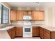 View of kitchen featuring white appliances, oak cabinets, neutral countertops, and a sink with natural light at 1944 N Lazona Dr, Mesa, AZ 85203
