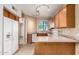 Traditional kitchen with wooden cabinets, white appliances, track lighting, and neutral countertops at 1944 N Lazona Dr, Mesa, AZ 85203
