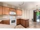 Kitchen area featuring oak cabinets, white appliances, bar countertop, and a view to the dining area at 1944 N Lazona Dr, Mesa, AZ 85203