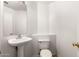 Bright powder room featuring a pedestal sink, toilet, and neutral paint at 1944 N Lazona Dr, Mesa, AZ 85203