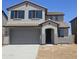 Charming two-story home featuring a gray exterior, gray garage door, and a beautifully tiled roof at 22392 W Monona Ln, Surprise, AZ 85387
