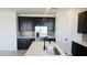 Modern kitchen featuring stainless steel appliances, dark cabinets, light countertops, and stylish tile backsplash at 22392 W Monona Ln, Surprise, AZ 85387