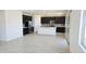 Bright kitchen with stainless steel appliances, dark cabinetry, a kitchen island, and light wood-style flooring at 22392 W Monona Ln, Surprise, AZ 85387