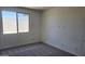 Bright bedroom with carpet flooring and a large window overlooking the backyard at 22400 W Monona Ln, Surprise, AZ 85387