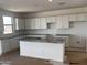 Bright kitchen with granite countertops, white cabinets, and a central island with sink at 22400 W Monona Ln, Surprise, AZ 85387