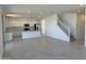 Bright, open living area with staircase and adjacent kitchen featuring modern, white cabinets at 22400 W Monona Ln, Surprise, AZ 85387