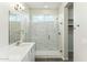A bright bathroom features a glass shower with marble tile and a large vanity with mirror at 23259 S 194Th Dr, Buckeye, AZ 85326