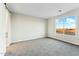 A light filled bedroom features a plush carpet and a large window to enjoy the neighborhood view at 23259 S 194Th Dr, Buckeye, AZ 85326