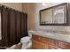 Stylish bathroom features granite countertops, a framed mirror, and a shower with a neutral curtain at 2612 S Jacob St, Gilbert, AZ 85295