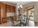 Bright dining area with glass table and chairs, built-in shelving, and sliding glass doors to patio at 2612 S Jacob St, Gilbert, AZ 85295