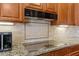 Close-up of the kitchen featuring granite countertops, modern cooktop, and stylish backsplash at 2612 S Jacob St, Gilbert, AZ 85295
