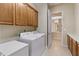 Functional laundry room with cabinetry, appliances, and access to the backyard through the doorway at 2612 S Jacob St, Gilbert, AZ 85295