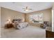 A sunlit main bedroom features neutral carpet and walls, a ceiling fan, and a large picture window at 2612 S Jacob St, Gilbert, AZ 85295