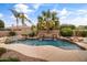 Beautiful pool featuring a rock waterfall, hot tub, and lush landscaping, creating a serene outdoor retreat at 2612 S Jacob St, Gilbert, AZ 85295