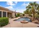 Backyard featuring a pool with rock waterfall, hot tub, and fire pit, perfect for outdoor entertainment and relaxation at 2612 S Jacob St, Gilbert, AZ 85295