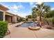 Backyard oasis featuring a pool with rock waterfall, a hot tub, and mature landscaping, creating a private retreat at 2612 S Jacob St, Gilbert, AZ 85295
