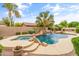 Beautiful pool with a rock waterfall, lush landscaping, and an outdoor grill, perfect for summer fun at 2612 S Jacob St, Gilbert, AZ 85295