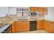 Kitchen area with oak cabinetry, tile backsplash, granite counters and stainless steel appliances at 2663 N Carriage Ln, Chandler, AZ 85224