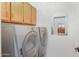 Functional laundry room showcasing a front-load washer, dryer, and upper cabinets for storage at 2663 N Carriage Ln, Chandler, AZ 85224