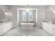 Bright bathroom with a luxurious freestanding tub, dual vanities, and stylish fixtures at 2988 E Comstock Dr, Gilbert, AZ 85296