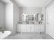 Bright bathroom features a double vanity with white cabinets and marble countertops at 2988 E Comstock Dr, Gilbert, AZ 85296