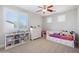 Comfortable bedroom with storage bed, bright windows, ceiling fan, and organized shelving unit at 2988 E Comstock Dr, Gilbert, AZ 85296