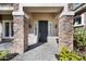 Charming front entrance featuring a stone facade, elegant black door, and well-maintained landscaping, showcasing curb appeal at 2988 E Comstock Dr, Gilbert, AZ 85296