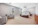 Spacious main bedroom with a ceiling fan, seating area, and large bed with bench at 2988 E Comstock Dr, Gilbert, AZ 85296
