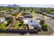 Expansive aerial view featuring solar panels, a fenced yard, and vibrant landscaping against a mountain backdrop at 3002 E Montecito Ave, Phoenix, AZ 85016