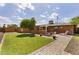The backyard features a lush lawn, mature trees and a brick path leading to a lounge area at 3002 E Montecito Ave, Phoenix, AZ 85016