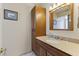 Bathroom with wood cabinet, granite counter, white sink basin, framed art, and tile flooring at 3002 E Montecito Ave, Phoenix, AZ 85016