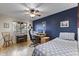 Comfortable bedroom featuring a wooden desk, ceiling fan, and blue accent wall at 3002 E Montecito Ave, Phoenix, AZ 85016