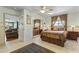 Cozy bedroom with large mirror doors, ceiling fan, lamps and overhead lighting, and view to the living room at 3002 E Montecito Ave, Phoenix, AZ 85016
