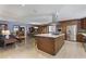 Open kitchen featuring wood cabinets, stainless appliances, and island with seating, leading into living and dining area at 3002 E Montecito Ave, Phoenix, AZ 85016